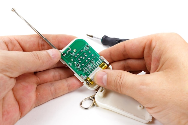 Photo disassembled security system remote control in man's hand