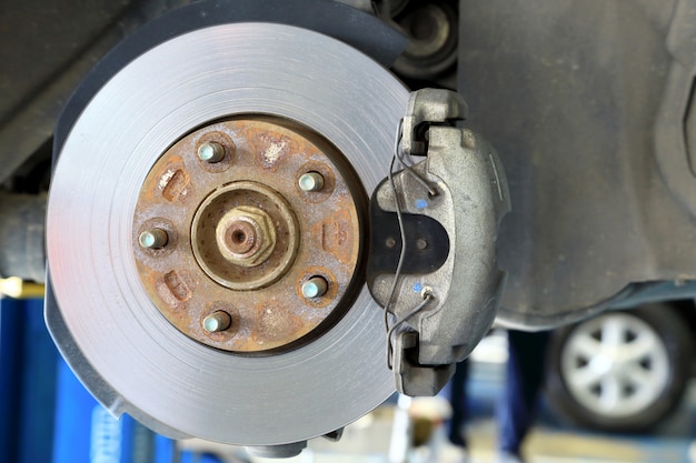 Freni a disco su auto in corso di sostituzione di pneumatici nuovi nel garage.