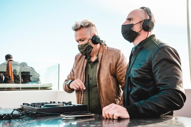 Disc jockeys playing music for tourist people at club party\
outdoor djs wearing headphones at music live event live event music\
and fun concept entertainment and party concept