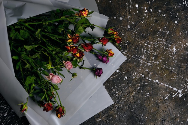 Discarded bouquet decorative roses dried flowers concrete floor