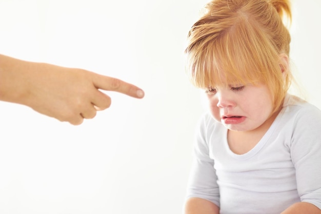 Discipline Its never fun A cute baby girl crying while her mother points at her