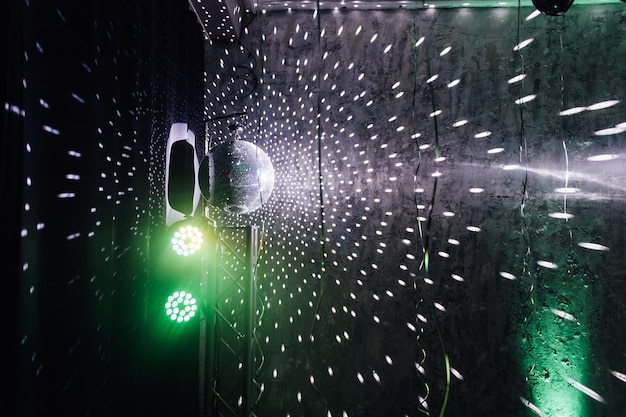 The disco ball mirror spins and reflects the light at the disco in the club