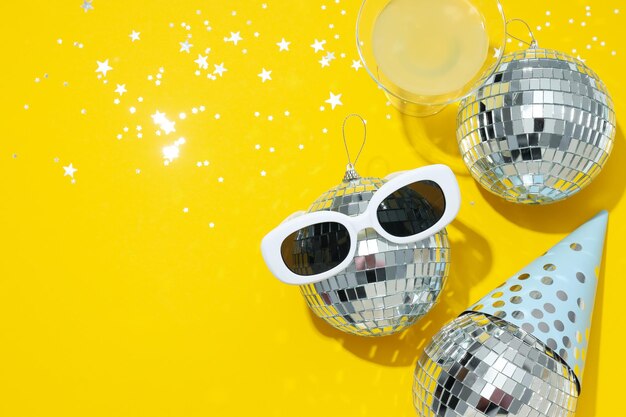 Disco balls with glasses on a yellow background