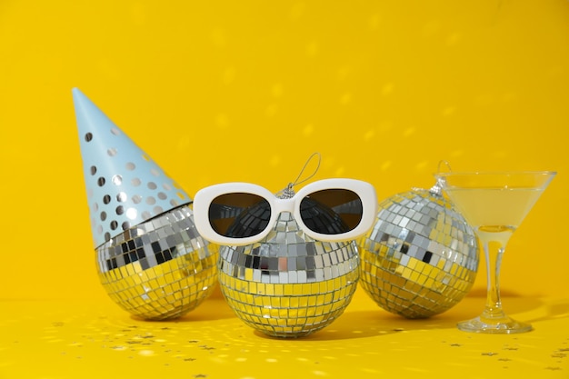 Disco balls with glasses on a yellow background