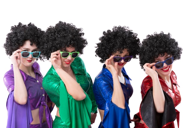 Disco style girls in colorful flared suits and African American wigs on a white background