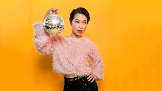 Discoball in hands of young woman celebrating birthday in night club