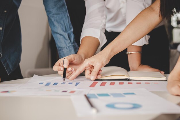 Discussie, brainstorm aziatische jonge zakenman, zakenvrouw analyseert grafieken, grafiek op document, bespreekt economische strategie op papierwerk voor bedrijven om te groeien op tafel op kantoor, werkplek.