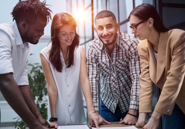 Discussing new project Group of modern people having a meeting while standing in the creative office