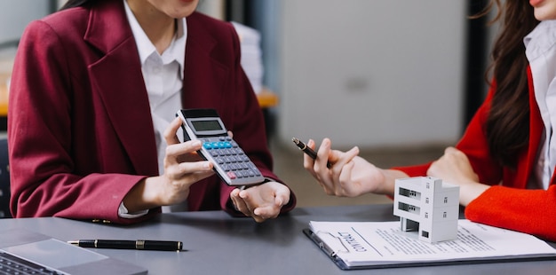 Discussion with a real estate agent House model with agent and customer discussing for the contract to buy get insurance or loan real estate or property