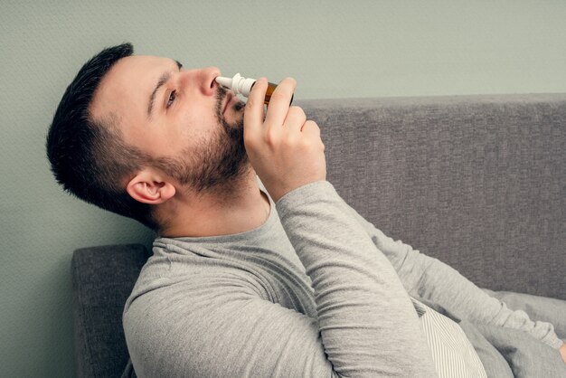 疾患。家で乾杯。若い男は病気で、自宅で治療されます。鼻をナプキン、鼻水に吹き込みます。感染、流行、バチルスキャリア。