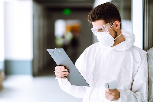 Disease control expert with a equipment to check the temperature at office.