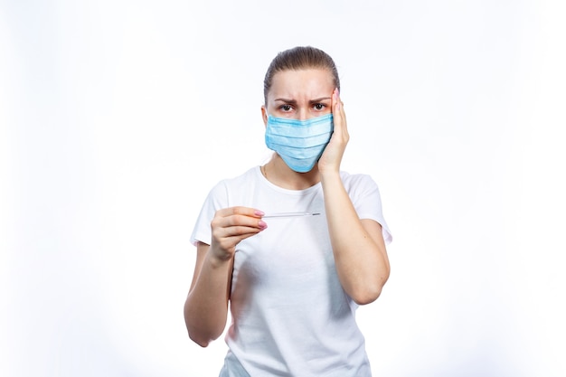 Diseased woman in protective medical surgical mask with a thermometer in his hand treated against the virus. Isolated on white background