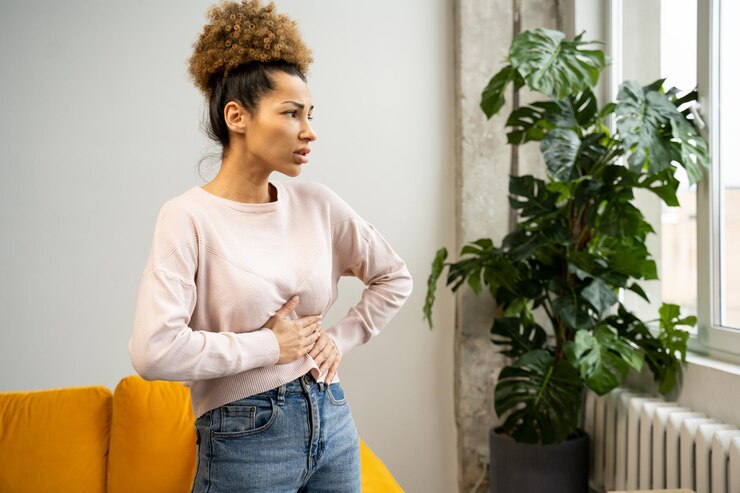 Photo a disgruntled africanamerican woman with curly hair suffers from abdominal pain touches her stomach