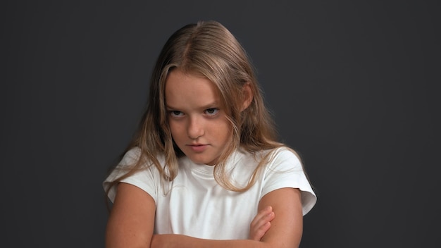 Disgruntled girl crossed her arms looking to side. Teen model expresses sad emotion. Problem concept