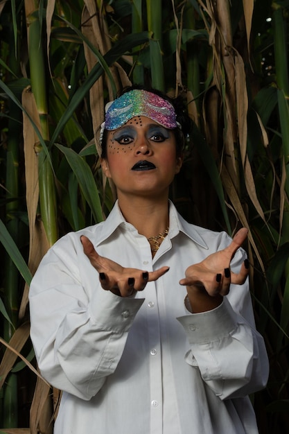 disguised doctor woman with make up and mask over her head with bamboo plants in the background