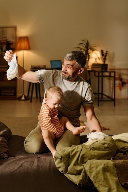 Disgusted man looking at dirty diaper