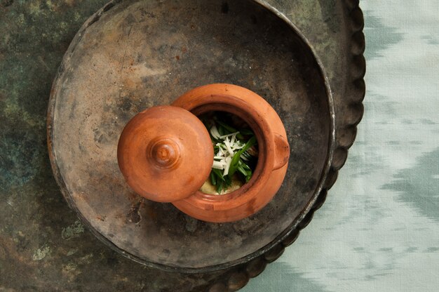 Dish in a clay pot on an old antique tray