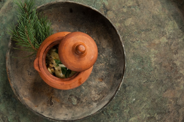 Dish in a clay pot on an old antique tray