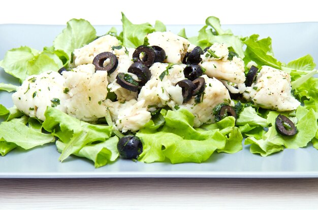 Dish of cod salad with black olives