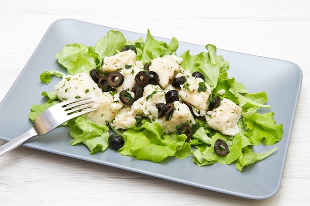 Dish of cod salad with black olives