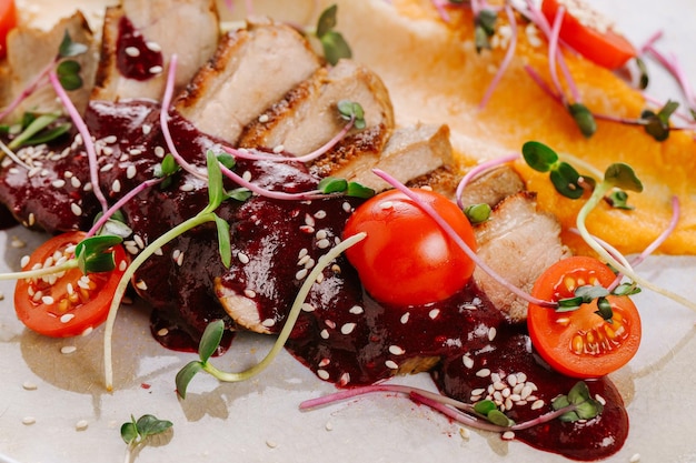 Dish of duckmeat with red sauce vegetables and greens