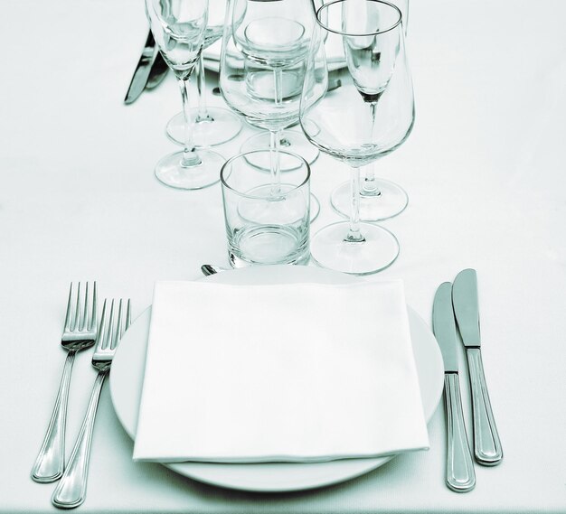 Dish forks knifes napkin empty glasses monocrome tone