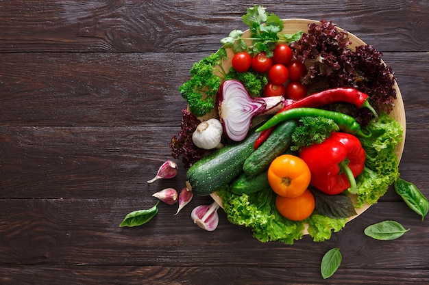 Dish of fresh vegetables on wood with copy space