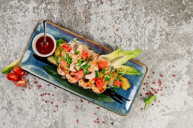 グレーの背景に海老と野菜を添えた春雨の料理 中華なべメニュー