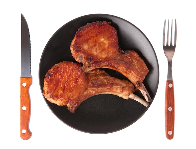 フォークとナイフは、白い背景で隔離の豚カルビのグリル料理