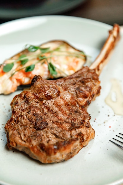 Dish plate with meat steak on the bone in the restaurant