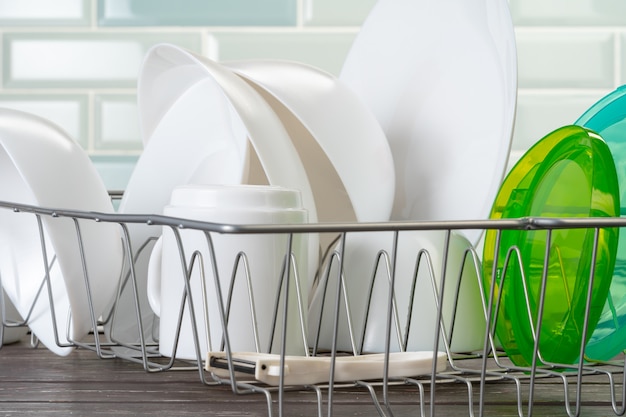 Dish rack with clean dry dishes on kitchen counter