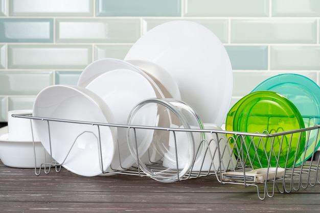 Dish rack with clean dry dishes on kitchen counter