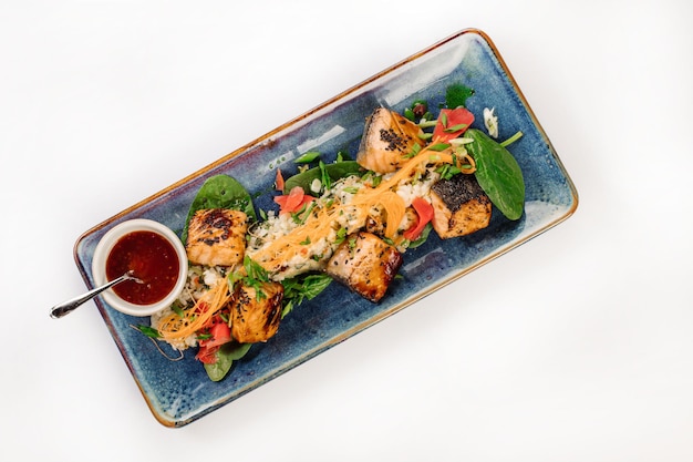 Photo dish of roasted fish pieces with rice peas and vegetables wok menu