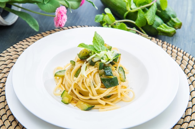 Dish of spaghetti with zucchini and mint leaves