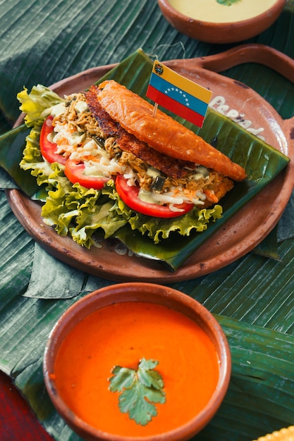 Dish on a table with green leaves, empanada stuffed with vegetables. Fried food.
