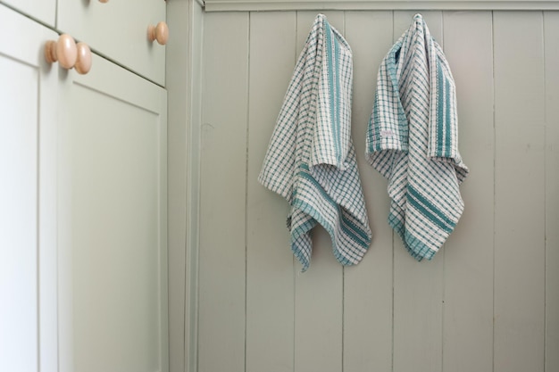 Photo dish towels hanging on wooden wall in kitchen at home