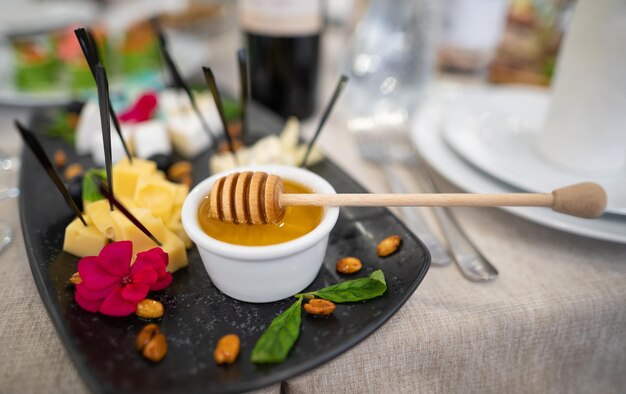 A dish of various delicious cheeses and a plate of honey