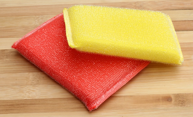 Photo dish washing sponge, dishcloth and scrub pad on wooden background