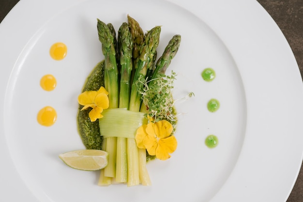 Dish with boiled asparagus and sauce. Detox menu