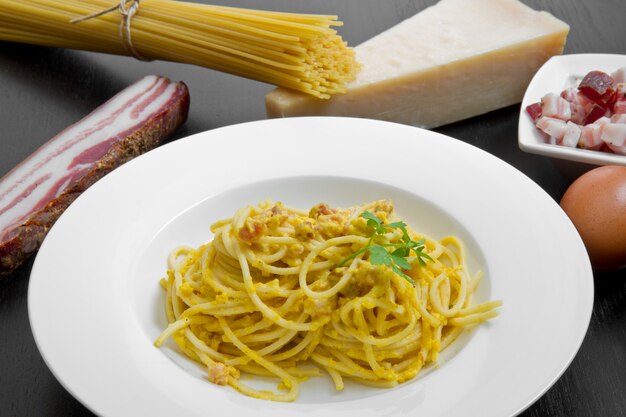 Dish with carbonara's spaghetti and ingredients