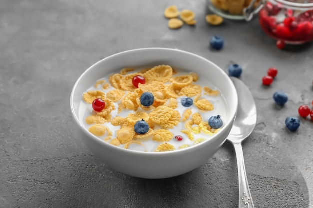 Photo dish with cornflakes and milk on table