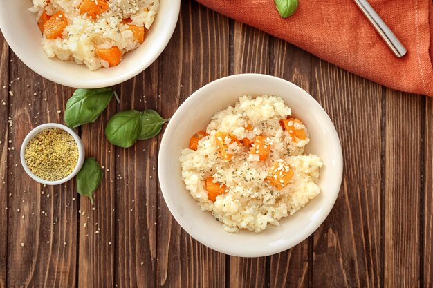 Dish with delicious pumpkin risotto on wooden table