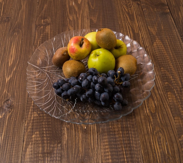 다른 과일이 담긴 접시가 나무 탁자 위에 있다