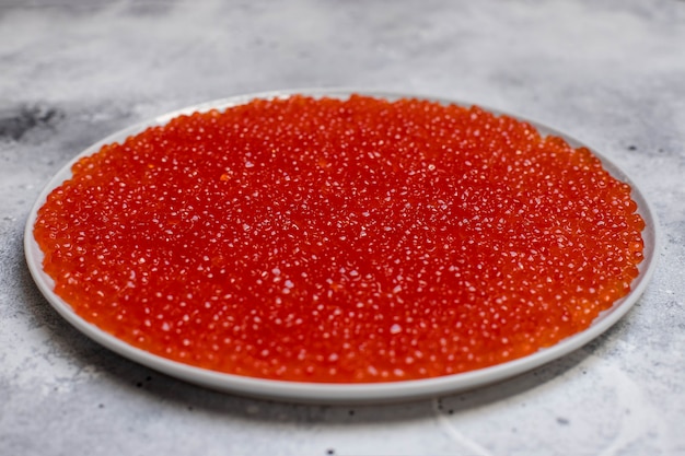 Dish with fresh red caviar, close-up. Healthy seafood. light background