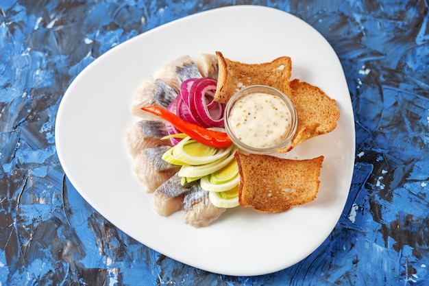 Dish with herring on a white plate. Top view. The concept of foo