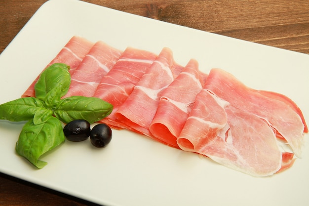 dish with raw ham and breadstick