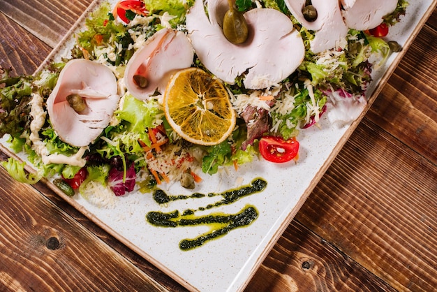 Photo a dish with smoked ham and vegetables on wooden background