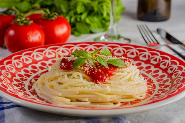 Dish with spaghetti in tomato sauce and basil