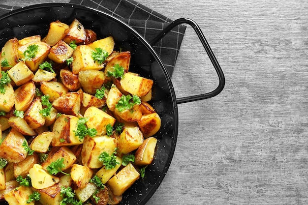 Dish with tasty potato wedges on table