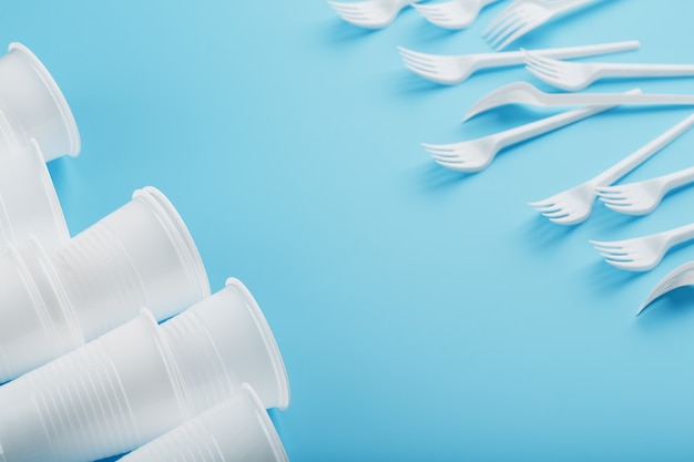 Dishes made of white plastic on a blue wall.